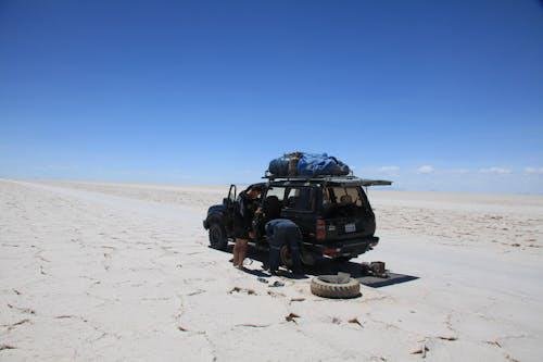 A stranded vehicle on the roadside receiving emergency assistance for fuel or repairs.