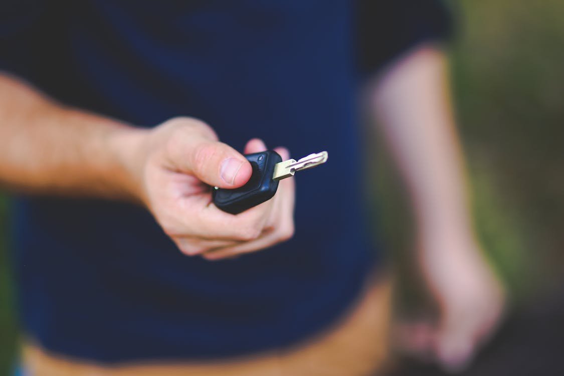 A person holding a car key in their hand.