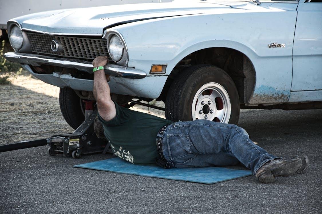 An image of a mechanic working under a car