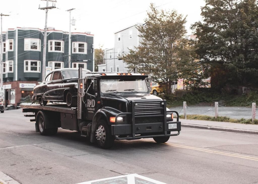 An image of a black tow truck carrying a car