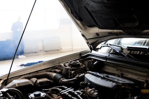 A car parked with its hood open, possibly due to engine trouble.